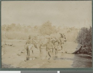 Carriers crossing a river, Zambezia province, Mozambique, 23-29 July 1918