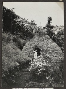 African woman with baby behind Moshi hut, Tanzania