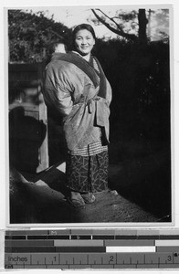 Smiling Japanese woman wearing a winter coat, Japan, ca. 1930-1950