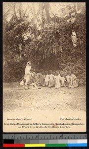 Missionary sister and small children praying before a statue, India, ca.1920-1940