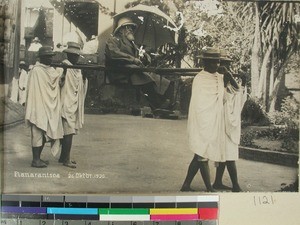 Outdoor portrait of a person carried in a sedan chair, Fianarantsoa, Madagascar, 1920-10-26