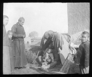 Fr. Anthony Cotta, MM, visiting a father and child, China, ca. 1906-1919