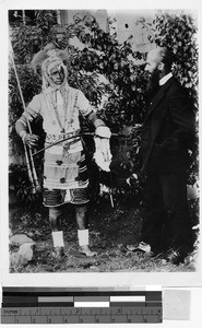 Missioner standing with a man in costume, Africa, April 13, 1943