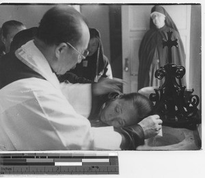 A native priest baptizing at Fushun, China, 1936