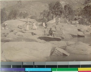 Women thrashing rice near a river, Madagascar