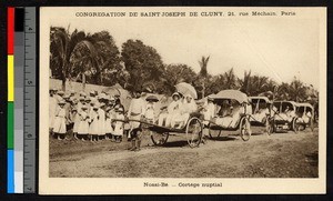 Newlyweds drawn in a hand-drawn carriage in a wedding procession, Madagascar, ca.1920-1940