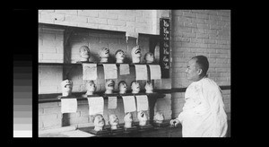 Dr. D. S. K. Dai with models of dental diseases, Chengdu, Sichuan, China, ca.1946