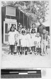 Group of children with Maryknoll Priest, Jerome Relocation Center, Denson, Arkansas, ca. 1942