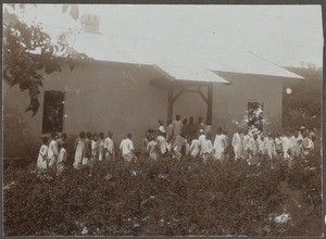 Crowd of people in front of a European style house, Tanzania