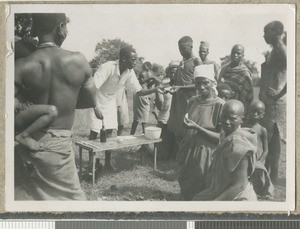 Dresser examines a prescription, Eastern province, Kenya, ca.1949