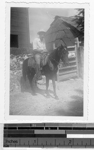 Man on horseback in front of his home, Carrillo Puerto, Quintana Roo, Mexico, ca. 1945