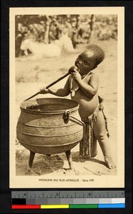 Young child licking a spoon, South Africa, ca.1920-1940