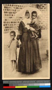 Missionary sister holding an infant in one arm and the hand of a child with the other, Congo, ca.1920-1940