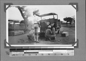 Repairing the broken axle of a car, Tanzania, ca.1929-1930