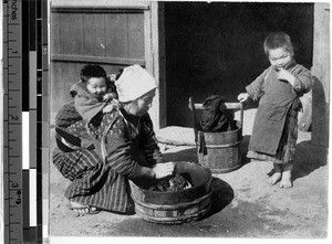 Japanese mother washing laundry, Japan, ca. 1910/1930