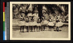 Dancers wearing grass skirts and holding sticks, Congo, ca.1920-1940