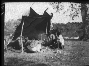 Group of African people by a fire, Mozambique, ca. 1901-1907