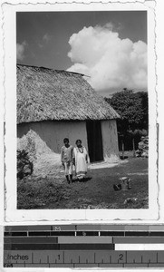 Mayan couple standing in front of a thatched-roof building, Carrillo Puerto, Quintana Roo, Mexico, ca. 1944