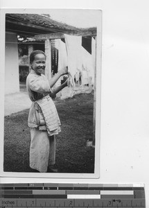 A girl hangs clothes to dry at Luoding, China, 1935