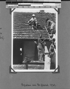 Missionary Schärf and Africans tile a roof, Mbozi, Tanzania