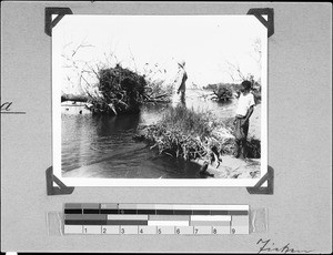 A missionary and a boy standing on the lakeshore of Lake Malawi, Mwaya, Tanzania, 1936