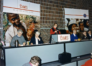 DMS-repræsentantskabsmøde på Nyborg Strand i 1996. Karen Berntsen på talerstolen; siddende ved podiet: Anders Mielke, Kamma Christensen, dirigent (navn ikke kendt), Knud Sørensen og Verner Tranholm-Mikkelsen