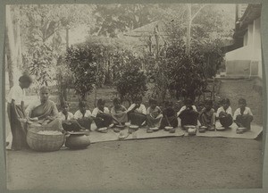 Orphans eating rice. On the right the boarding school. In the background the mission house