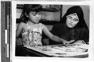 Sr. Helen Mary, MM, conducting play therapy with a girl, Honolulu, Hawaii, ca. 1935-1955