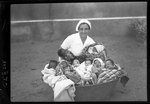 Miss Golaz with babies of the maternity ward, Chamanculo, Maputo, Mozambique, 1940