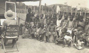 Children gathered around missionary playing the piano, Africa, ca. 1930-1940