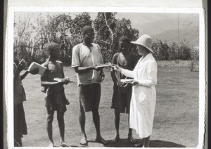 For the sake of obtaining a Bible these young men trek for weeks with the missionary, invite their countrymen to listen to him preaching, form a choir with him, sleep with him in poverty-stricken huts, go through the deep waters, suffer hunger and thirst. When they get home they receive the book they desire, and also the pay for their work. Here Mrs Zürcher is giving copies of the new Testament to the young men as reward for their work. Today they are students in the Bible School in Bali