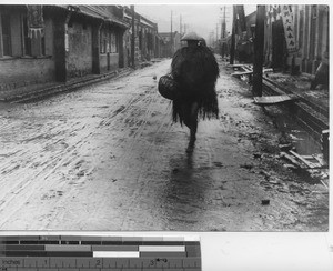 A man with a straw raincoat at Fushun, China, 1940