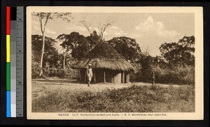 Missionary father standing before thatched hut, Congo, ca.1920-1940