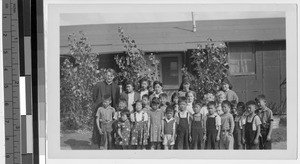 Group of children with Maryknoll missioners at Japanese Relocation Camp, Manzanar, California, ca. 1944