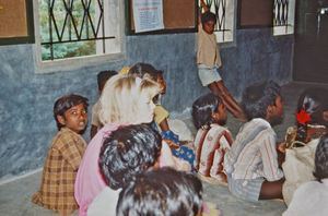 24.- Mission for børn i Indien. Diasserie 1990, "Da jeg blev velsignet af en elefant". Her sidder jeg og følger undervisningen. Selv om det er en ny skole, er der ikke glas i vinduerne. Og vi sidder stadig på gulvet