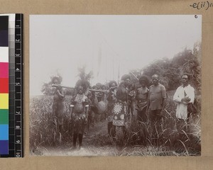 Men carrying slaughtered pig for wedding feast, Delena, Papua New Guinea, ca. 1905-1915