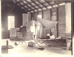 Reverend W.T. Balmer, sleeping on camp bed in school room, Sierra Leone, 1909