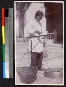 Young woman using a scale, Shantou, Guangdong, China, ca.1920-1937