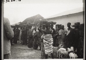 Abnahme des Wassertopfs beim Ueberbringen der Geschenke des Begorokönigs zur Synode 1935. (Ein Königsbote m. entsprechender Kopfbedeckung hilft den Topf abnehmen)