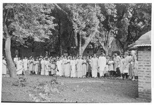 Santal Parganas, Nordindien. Elever og lærerstab ved Maharo Pigeskole. Til højre står gæster med blomsterkranse. (Skolen blev grundlagt af den norske missionær Anna Kristine Jensen (1866-1946). Arbejdssteder: Benagaria 1908-1911, Maharo 1911-31)