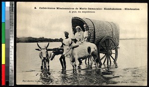 Missionaries fording a body of water in a covered wagon, Kumbakonam, India, ca.1920-1940
