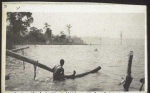 Views of lake Bosomtsche - Since the lake is sacred and the fetish priest does not allow the use of canoes the people use wood to sit on and row out to put up their nets