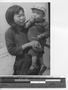 A Chinese girl holds her brother at Chaoyangzhen, China, 1941