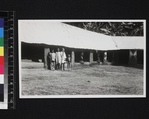 Children standing by fetish house and statues, Nigeria, ca. 1934-40