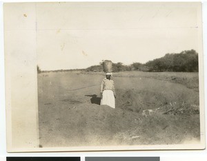 Zulu woman carrying a metal bucket on her head, South Africa