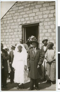 Bridal couple and others in front of a stone building, South Africa