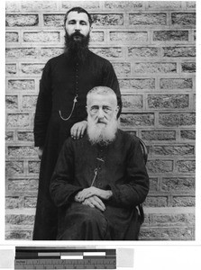 Two priests by a brick wall, Tibet, July 24, 1912