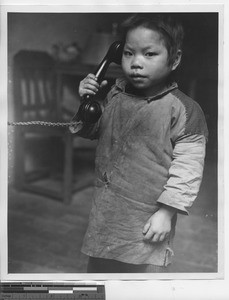 A boy talking on the telephone at Wuzhou, China, 1948