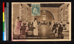 Missionary administering medicine in a hospital ward, Angola, ca.1924