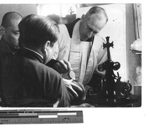 Fr. Geselbracht baptizing a boy at Fushun, China, 1936